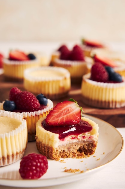 Prise de vue en grand angle de petits gâteaux au fromage avec de la gelée de fruits et des fruits sur une plaque en bois