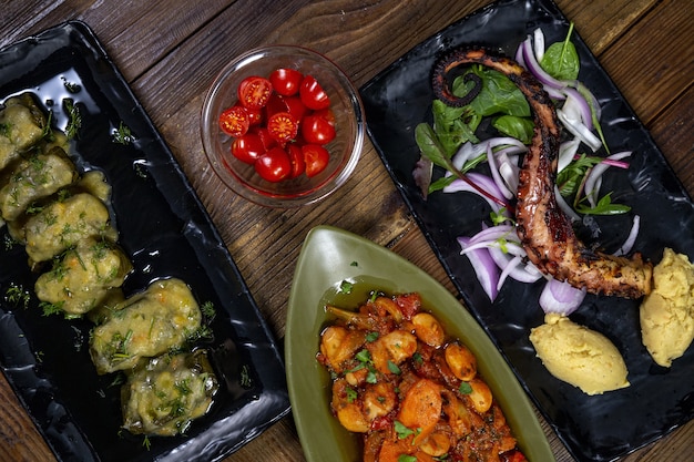 Prise de vue en grand angle d'une pieuvre grillée et pommes de terre avec différents légumes