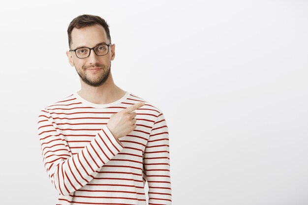 Prise de vue à l'intérieur d'un homme européen heureux et confiant avec des poils en lunettes noires