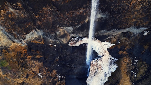 Photo gratuite prise de vue par drone d'une cascade de foss sauvages, d'un débit de rivière coulant sur des falaises gelées. belle cascade islandaise en islande coulant des montagnes, paysage panoramique fantastique. ralenti.