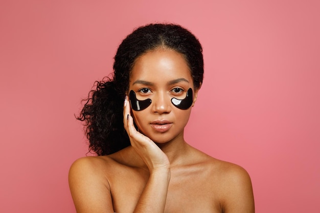 Prise de vue en studio d'une jeune femme avec des coussinets de gel pour les yeux sur son visage