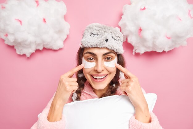 Prise de vue en studio d'une jolie fille qui pointe des taches de beauté sous les yeux