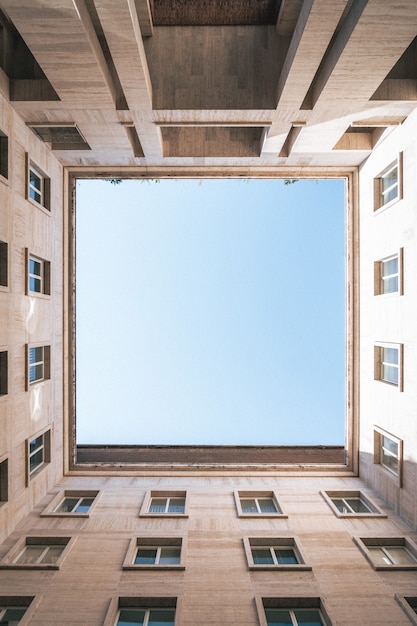 Prise de vue verticale à faible angle d'un carré avec le ciel formé par les bâtiments