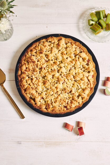 Prise de vue verticale à grand angle d'une assiette de tarte croustillante gâteau Rhabarbar et quelques ingrédients sur une table