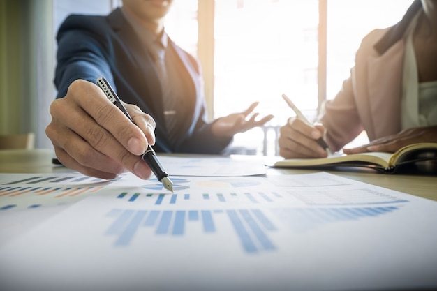 Processus de travail en équipe. Les jeunes chefs d&#39;entreprise travaillent avec un nouveau projet de démarrage. Labtop sur la table en bois, clavier de saisie, message textuel, analyse les plans graphiques.