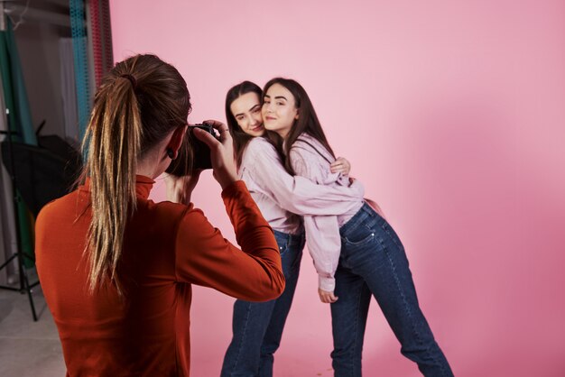 Processus de travail. Photo de deux filles qui s'embrassent et sont photographiées par une caméraman dans le studio