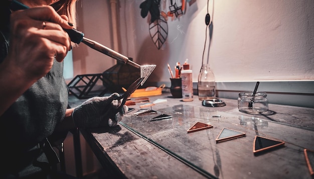 Photo gratuite processus de travail avec de la soudure au fer, fabrication d'une nouvelle partie de la lampe. séance photo en gros plan.