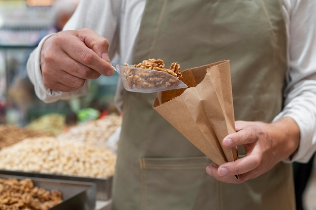 Photo gratuite producteur à sa boutique avec des aliments frais