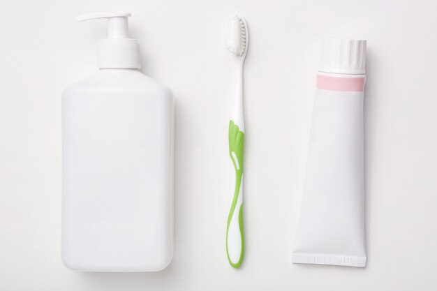 Produits cosmétiques naturels isolés sur un mur blanc Dentifrice, brosse à dents et bouteille de crème. Concept de beauté. Hygiène