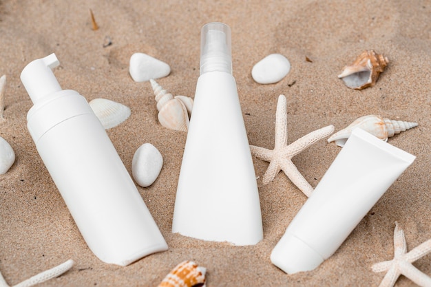 Produits pour la peau dans différents récipients dans le sable