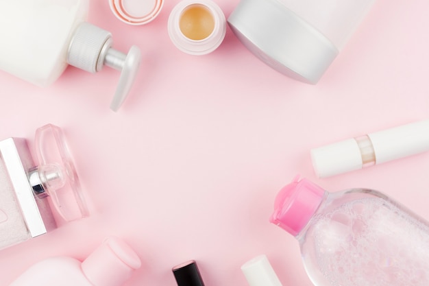 Produits de soin du visage rose créant un cadre rond