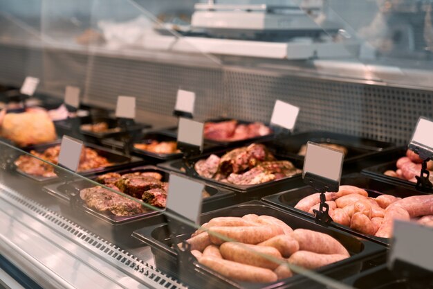 Produits de viande crue dans un comptoir en verre.