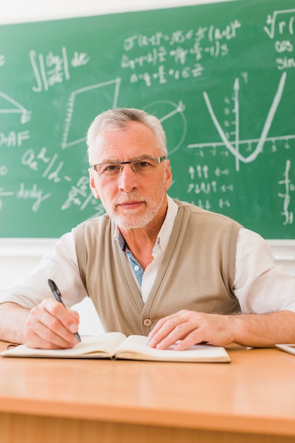 Professeur âgé écrit dans la salle de lecture