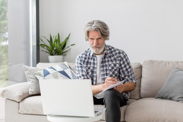 Photo gratuite professeur à mi-parcours regardant un ordinateur portable et écrit