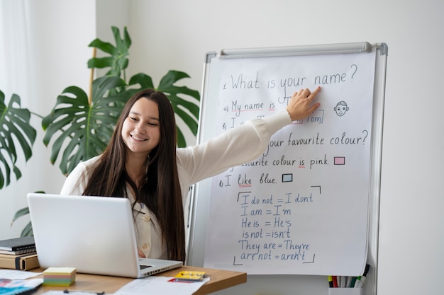 Photo gratuite professeur de plan moyen expliquant avec un tableau blanc