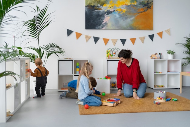 Professeur à plein régime regardant les petits enfants apprendre