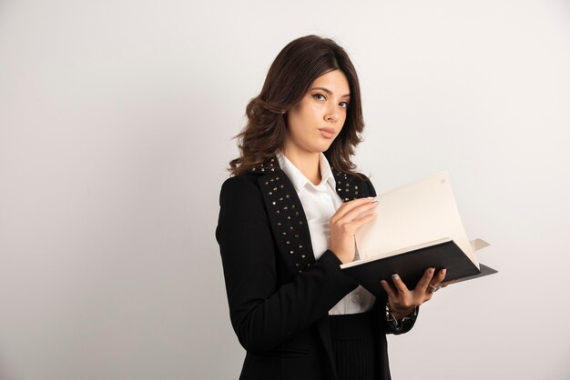 Professeur sérieux regardant à travers le cahier.