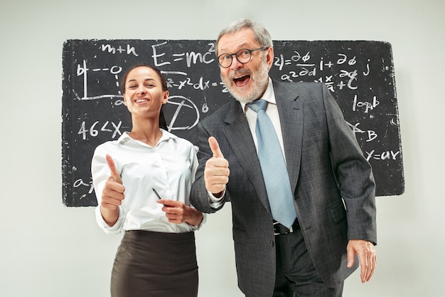 Professeur de sexe masculin et jeune femme contre le tableau noir en classe