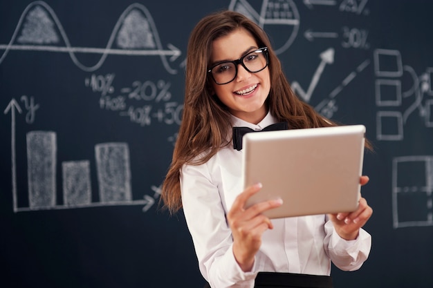 Professeur souriant à l'aide de tablette numérique en classe