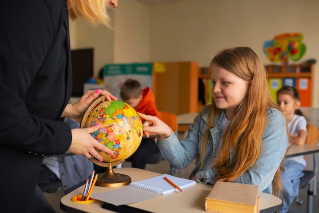 Professeur de vue de côté aidant les enfants