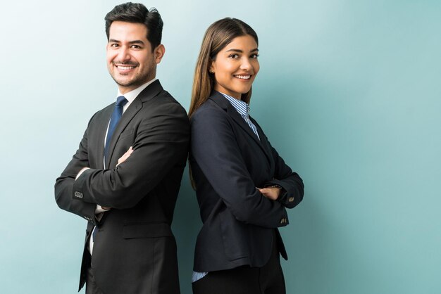 Professionnels confiants latins en costume debout sur fond isolé