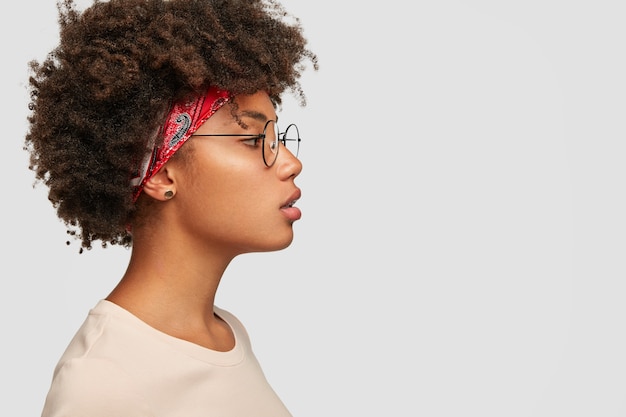 Profil de femme sérieuse avec une peau saine et pure, a une coiffure touffue