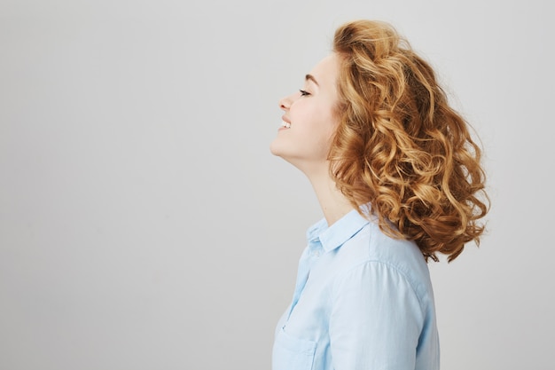 Profil de femme souriante insouciante avec coupe courte et bouclée