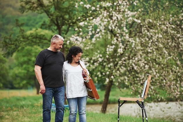 Profiter de la peinture. Beau couple d'âge mûr se promener dans le parc à loisir