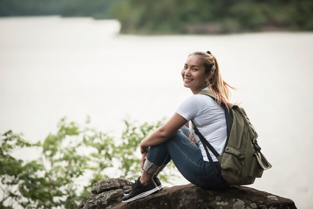 Profitez de la jeune femme avec sac à dos avec forêt. Concept de voyage.