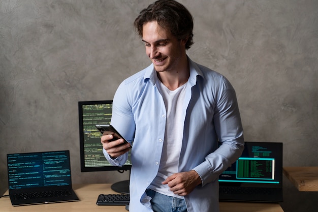 Programmeur de smiley à plan moyen tenant un téléphone