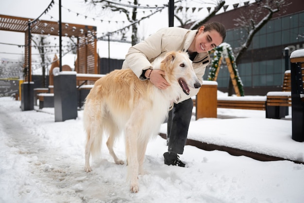 Photo gratuite le propriétaire passe du temps avec son chien lévrier