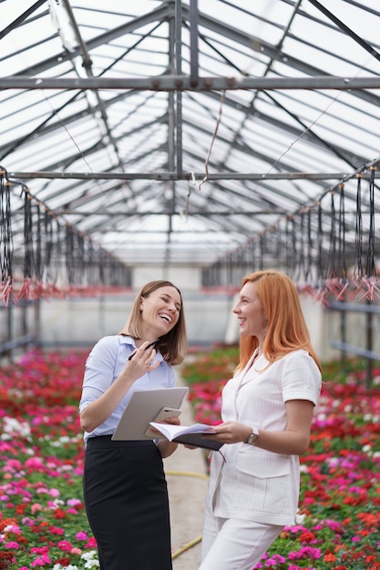 Le propriétaire de la serre présente des options de fleurs à un détaillant client potentiel.