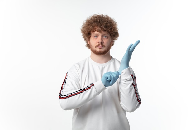 Protège Ta Peau. Homme Portant Des Gants De Protection Sur Un Mur Blanc.