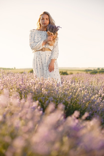 Provence femme détente dans le champ de lavande. Dame en robe blanche. Fille avec bouquete de fleurs.