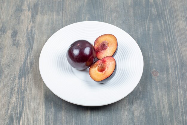 Prune cerise rouge isolé sur une plaque blanche