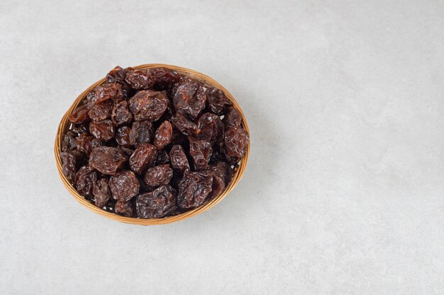 Prunes brunes séchées dans une tasse en céramique.