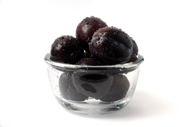 Prunes de cerise noire dans une tasse en verre