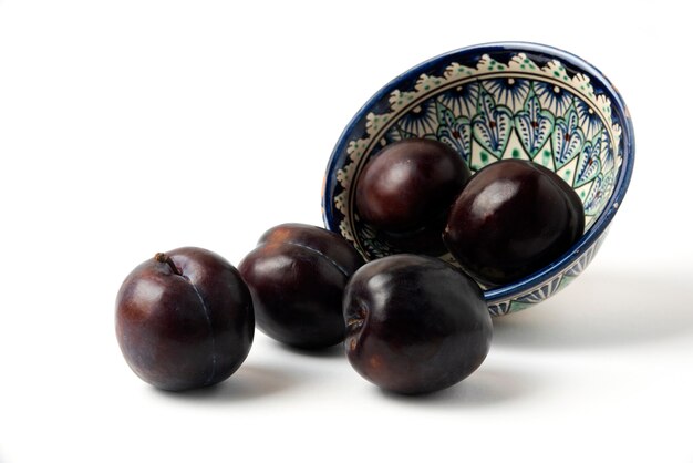 Prunes cerises noires dans une soucoupe ethnique