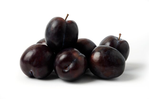 Prunes cerises noires sur la table blanche