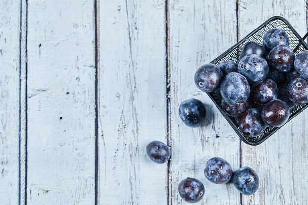 Prunes de jardin sur une table bleue.