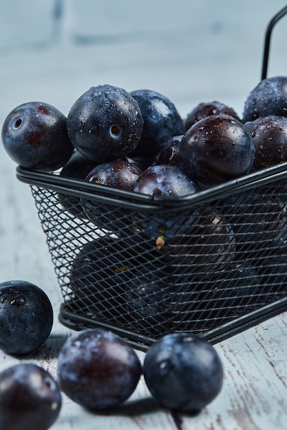 Prunes de jardin sur table bleue.