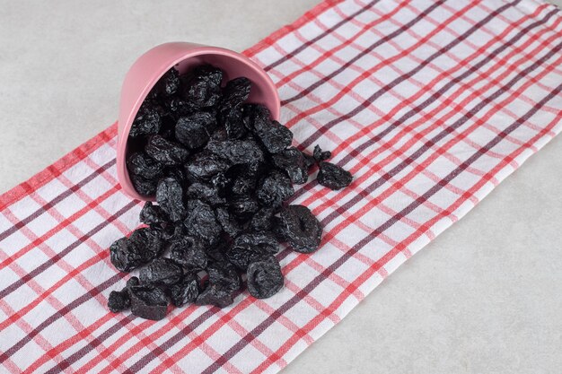 Photo gratuite prunes noires séchées dans un plat en céramique.