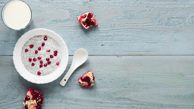 Photo gratuite pudding de graines de chia avec des graines de grenade dans un bol blanc avec une cuillère