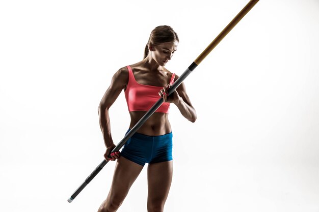 Puissance, beauté et pureté. Formation professionnelle de saut à la perche féminine sur fond de studio blanc.