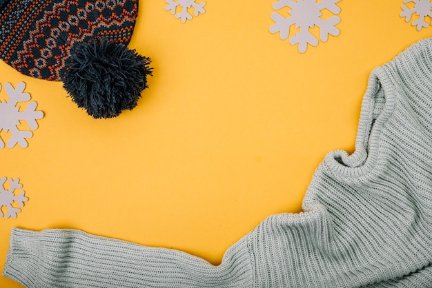 Photo gratuite pull et bonnet près des flocons de neige