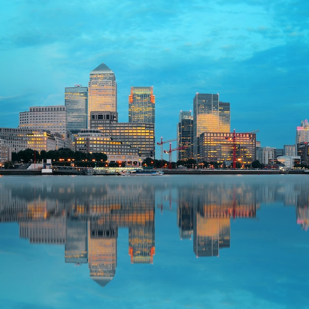 Photo gratuite quartier des affaires de canary wharf à londres au coucher du soleil avec réflexion.