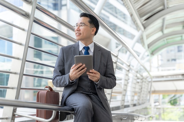 Quartier des affaires de l'homme d'affaires asiatique portrait, dirigeant de cadres visionnaires supérieurs avec ordinateur téléphone visionled entreprise à la main - concept de gens d'affaires de style de vie