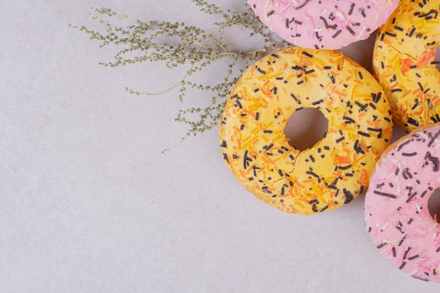 Quatre beignets sucrés colorés sur une surface blanche