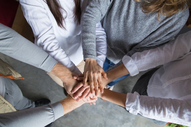 Photo gratuite quatre collègues joignant leurs mains