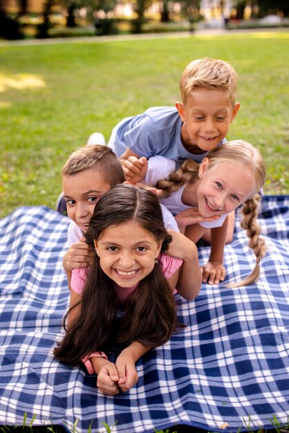 Quatre enfants heureux couchés sur une couverture